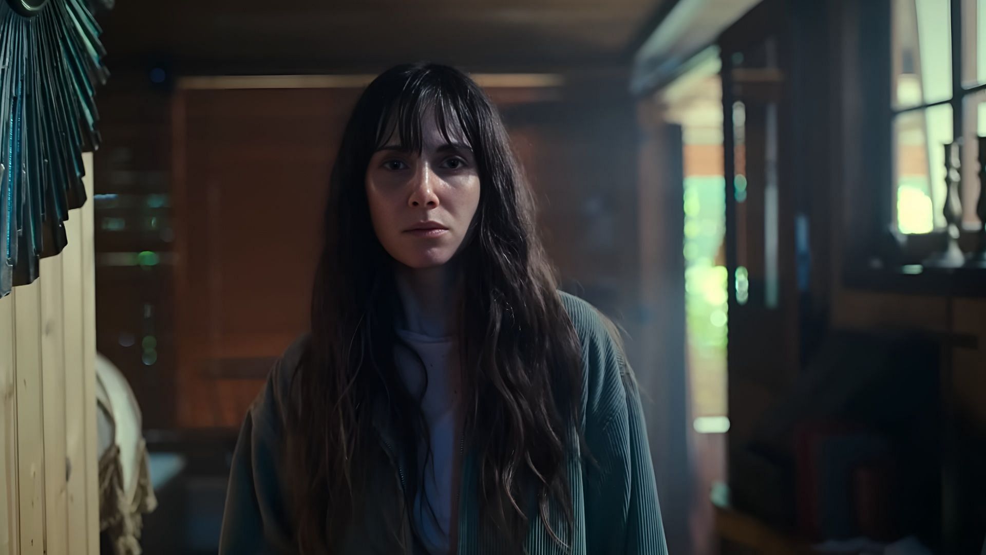 Millie stands alone in Together 2025, facing the growing horror of a love turned parasitic. (Image via NEON)